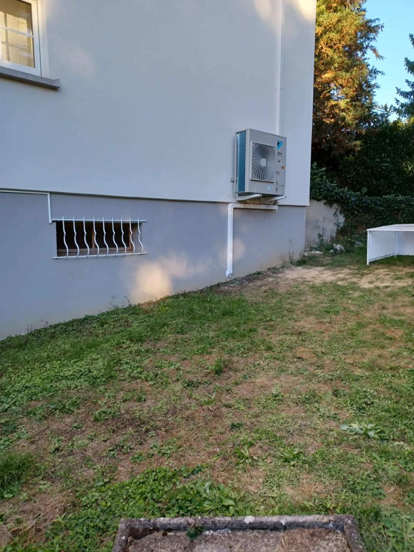 Unité extérieure de climatisation Daikin posée sur la façade d'une maison individuelle